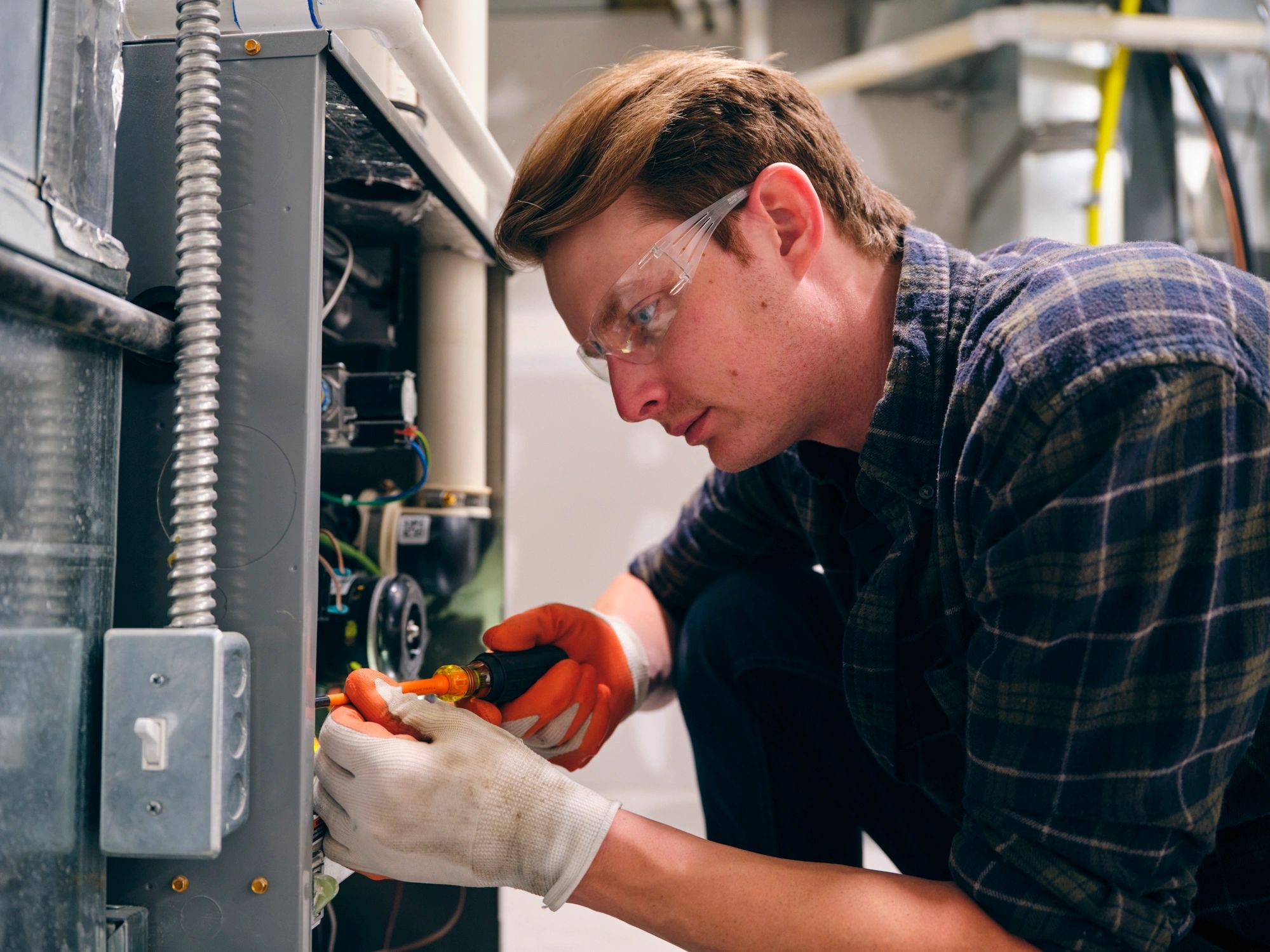 HVAC technician inspecting a residential furnace for performance