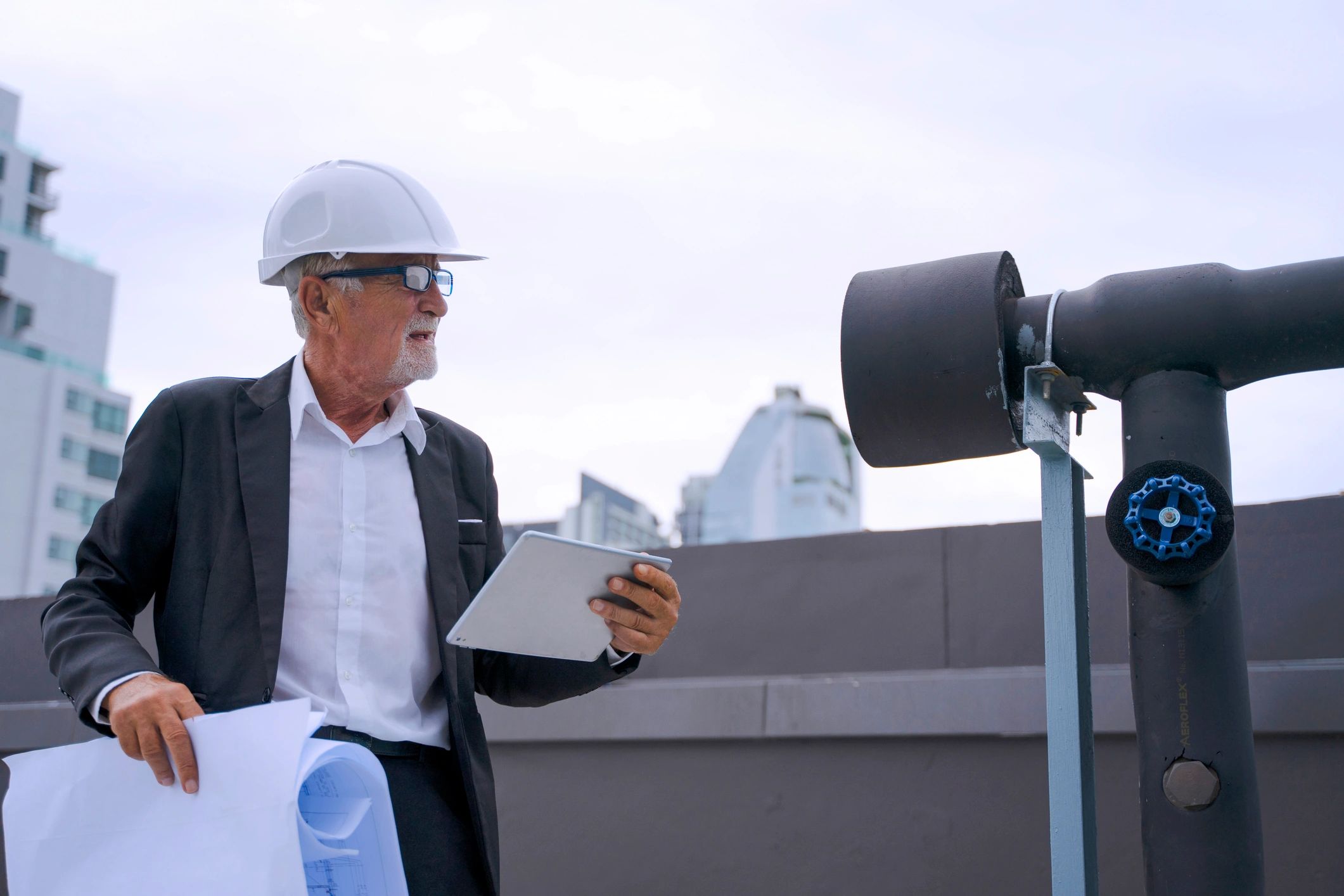 Engineer reviewing HVAC equipment on a rooftop