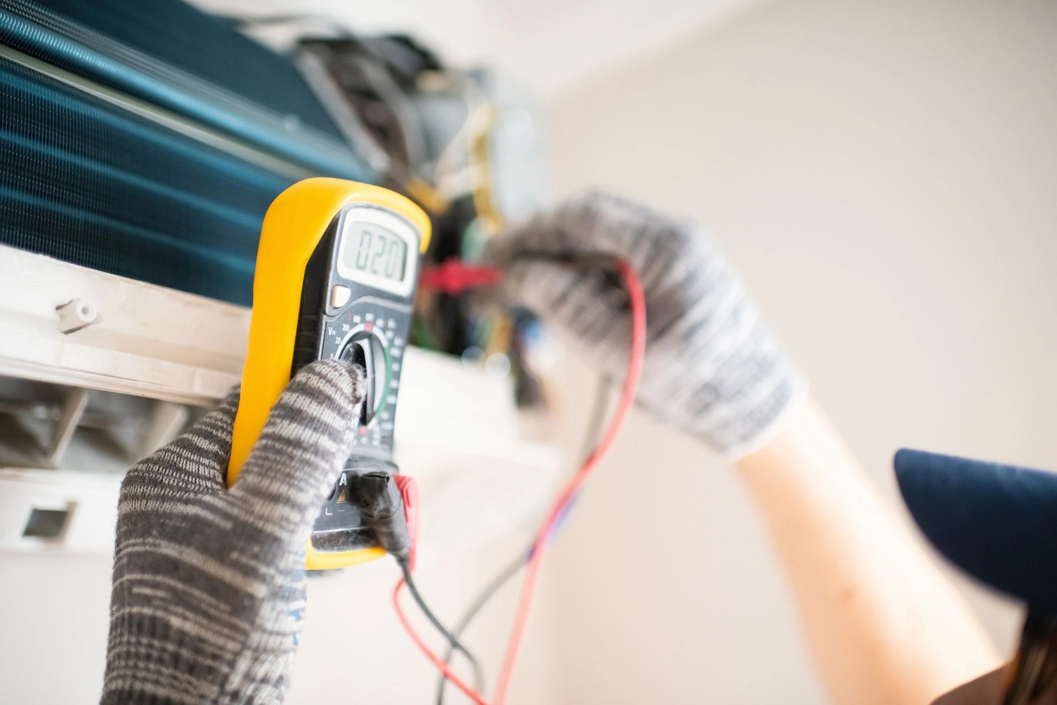 Technician testing an air conditioner with diagnostic equipment