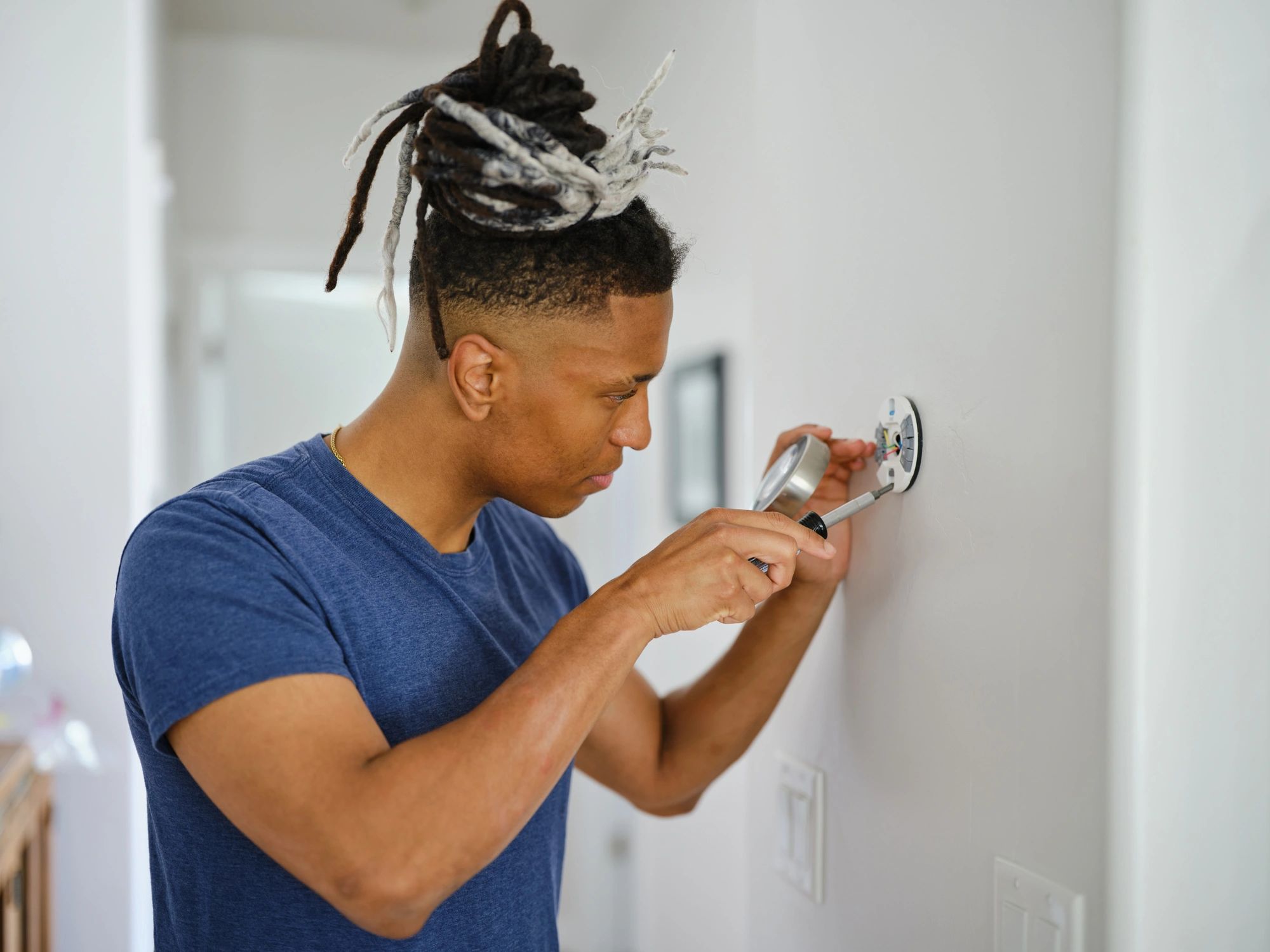 Technician installing a smart thermostat as part of an HVAC upgrade